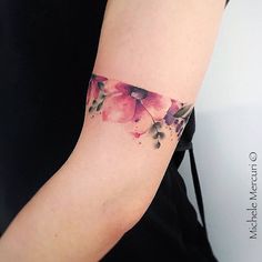 a woman's arm with watercolor flowers on it