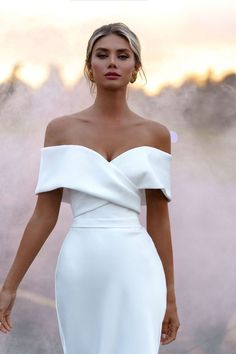 a woman in a white dress is posing for the camera with steam coming out of her face