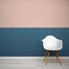 a white chair sitting in front of a blue and pink wall