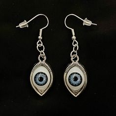 Please read descriptions thoroughly for sizes and materials. This is a pair of earrings with eerily realistic blue glass eyeballs, that seem to always be looking at you. They are a really fun and a little spooky! They are hung from standard hypoallergenic ear wires. Earrings are also available to be hung on 925 Sterling Silver ear wires, clip ons, 16-18mm Surgical Steel Hoops or 12-14mm Surgical Steel Hoops. Make sure to check out my shop for more hair pins, jewelry, earrings, accessories, and a Novelty Blue Drop Earrings, Handmade White Gothic Earrings, Blue Handmade Novelty Earrings, Handmade Blue Novelty Earrings, White Gothic Handmade Earrings, Hypoallergenic Drop Earrings For Halloween, Halloween Teardrop Jewelry Gift, Eyeball Jewelry, Eyes Creepy