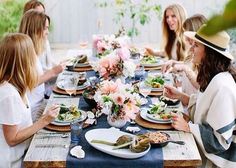 a group of women sitting around a table eating food