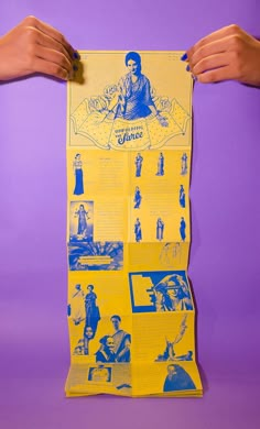 two hands hold up a poster with images of people and women on it, against a purple background