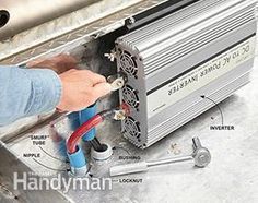 a person working on an electronic device in a metal container with other parts labeled around it