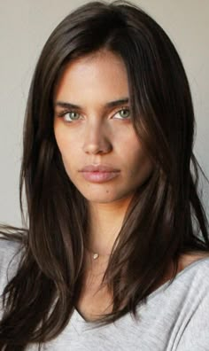 a close up of a person with long hair wearing a gray shirt and grey t - shirt