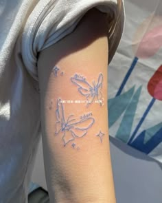 a woman's arm with white ink on the left side of her arm and two butterflies