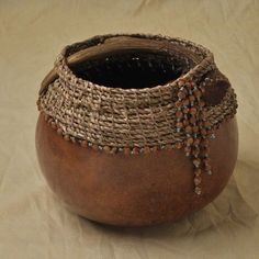 a brown bowl with beads on it sitting on a table