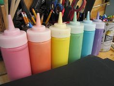 many different colored bottles with pens in them