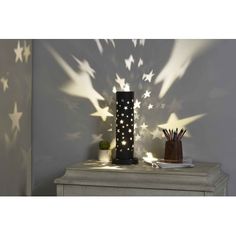 a lamp that is sitting on top of a table in front of a wall with stars