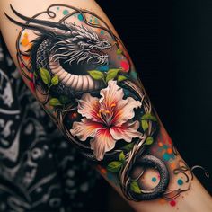 a dragon and flower tattoo on the arm