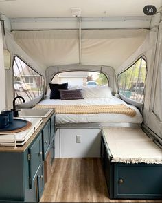 the inside of a camper with a bed, sink and kitchenette in it