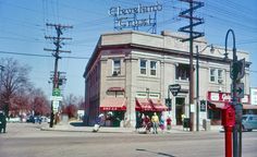 an old building on the corner of a street with people walking in front of it