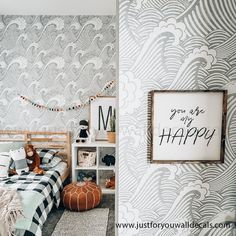 a child's bedroom decorated in gray and white with an artful wallpaper