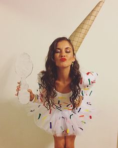 a woman in a white dress holding a mirror and an ice cream cone