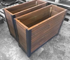 two wooden planters sitting next to each other on top of a cement floor in an industrial area