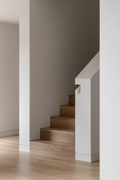 an empty room with wooden stairs and white walls