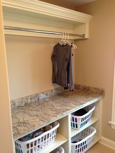 an organized closet with clothes and baskets on the shelf, next to a coat rack