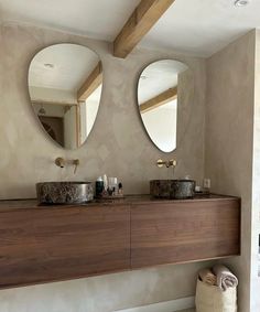 a bathroom with two sinks and mirrors on the wall