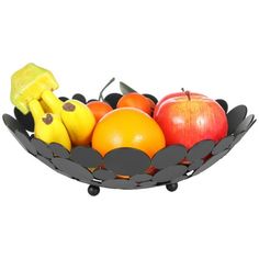 a fruit bowl with bananas, apples, oranges and other fruits in the shape of leaves