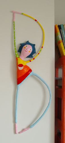 a child's toy hanging on the wall next to bookshelves