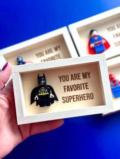 someone is holding up two legos in their boxes that say you are my favorite superhero