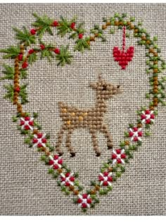 a cross stitch heart with a deer in it