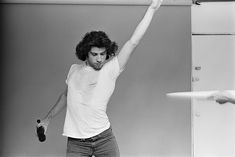 a man is holding his arms in the air while standing next to a refrigerator door