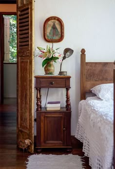 a bedroom with a bed, nightstand and clock on the wall next to an open door