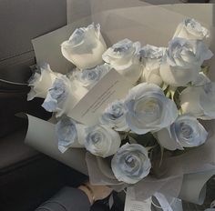 a bouquet of white roses sitting on top of a car seat