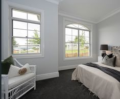 a bedroom with two windows and a bed