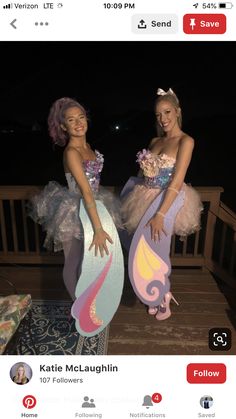 two women dressed as mermaids standing on a porch with their arms around each other