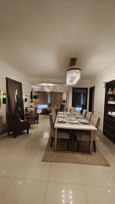 a large dining room with white tile flooring and chandelier hanging from the ceiling