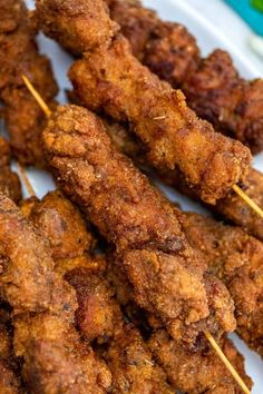 several skewers of food on a plate with toothpicks