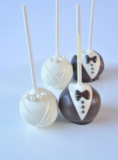 four chocolate covered cake pops with white and black decorations