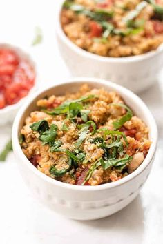 two white bowls filled with food on top of a table