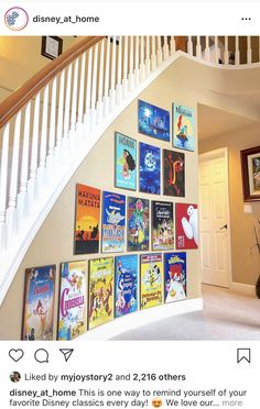 there are many books on the wall under the stairs in this house that is decorated with posters