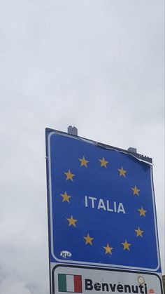 a blue street sign with the word italia written on it and yellow stars in italian