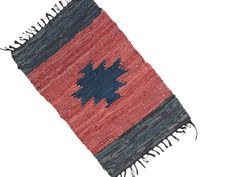 a red, blue and black rug with fringes on the bottom is laying flat