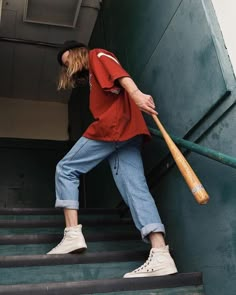 a person with a baseball bat standing on some steps