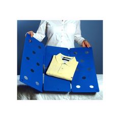 a woman is holding two blue bags with shirts on them and one has a yellow shirt in it