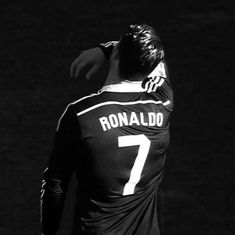 black and white photograph of a soccer player with his back to the camera looking down