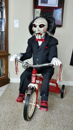 a creepy doll riding a tricycle in a living room