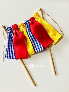 three red, yellow and blue candy bags on top of toothpicks with bows