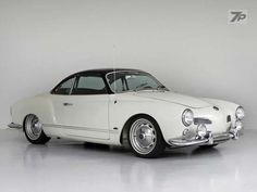 an old white car parked in a garage