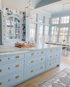 a large kitchen with blue cabinets and white counter tops, along with an area rug on the floor