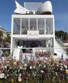 a building that has flowers in front of it and the word dior on top