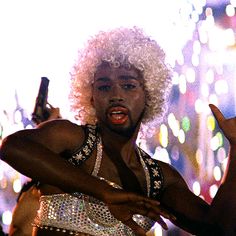 a man with an afro holding a beer in his hand