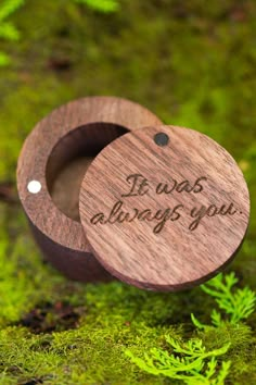 two wooden rings with the words if was always you engraved on them sitting in moss