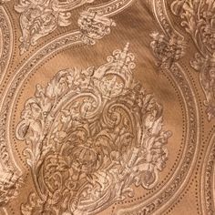 an intricately designed fabric is shown in gold and silver colors, as well as the design