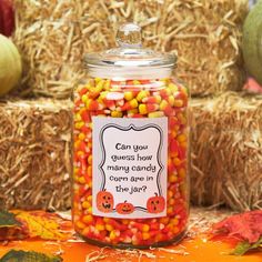 a jar filled with candy corn sitting on top of hay