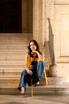 a woman sitting on the steps with her legs crossed